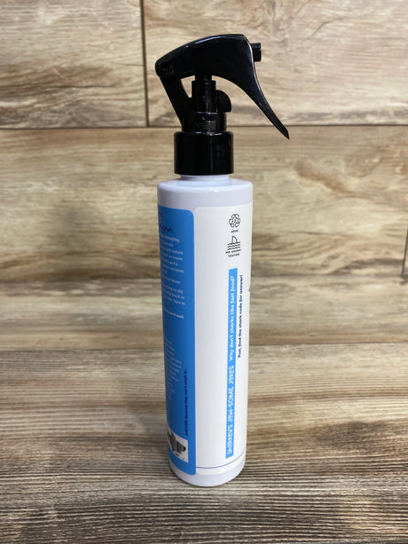 Side view of Sharkey's No More Knots detangler 8 oz bottle showing black spray trigger and blue label on wood background