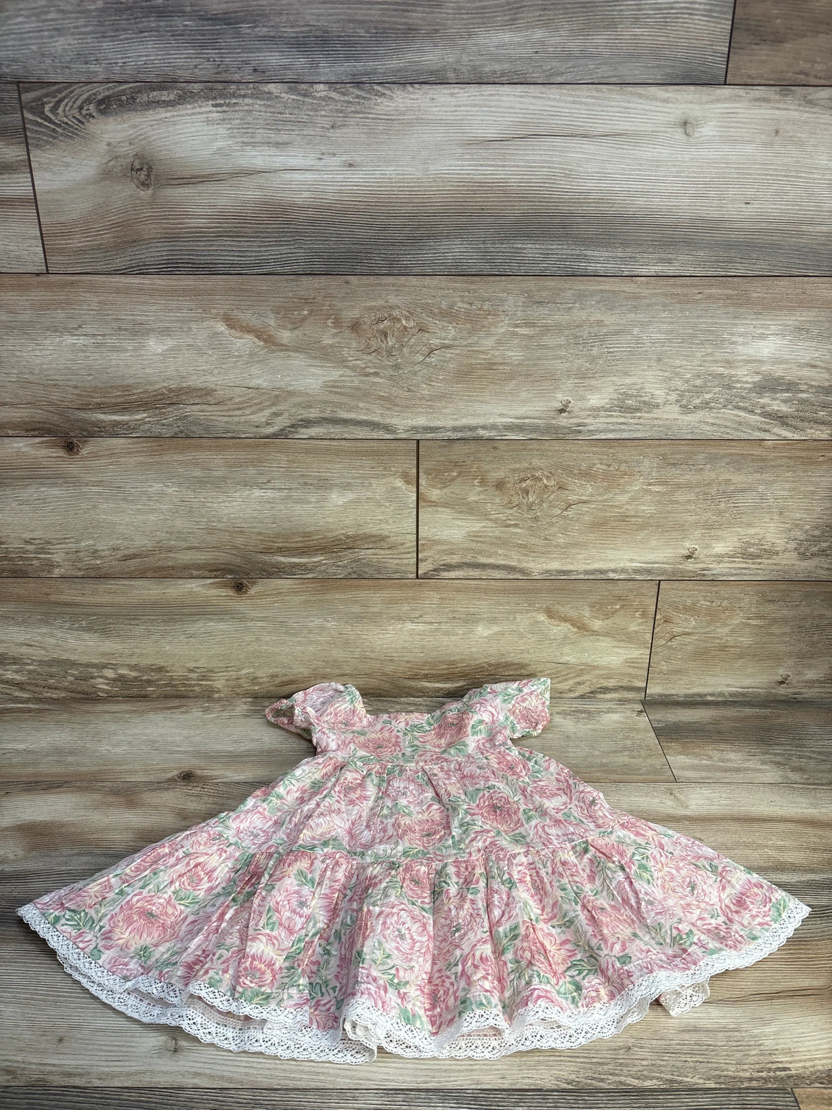 Flat lay of Joie pink floral button-tiered dress (3T) showing puff sleeves, tiered skirt and lace trim on wood floor