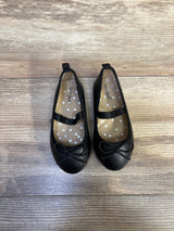 Top view of Cat & Jack Nora black slip-on ballet flats with elastic strap and bow on wood background