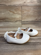 Side view of Wonder Nation white toddler ballet flats with elastic strap and back bow, gum sole on wood floor