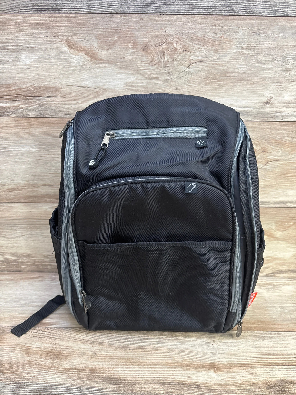 Front view of Fisher-Price Kaden FastFinder diaper bag in black showing front zip pockets, gray trim, and side bottle pocket