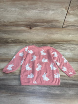 Pink kids sweater with white bunny print, long sleeves, laid on wood floor