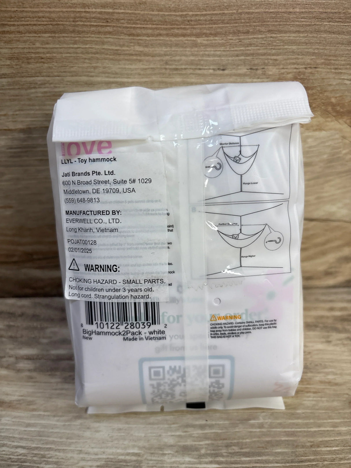 Back of Lilly's Love 2-pack toy hammock package showing warning label and hanging diagram on wood background