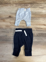 Flat lay of Carter's 2-pack preemie pull-on pants, light blue ribbed and navy pair with white drawstrings on wood surface