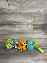 Top view of Bright Starts Take Along Carrier Toy Bar showcasing green strap with zebra tiger and mirror dangling toys on wood plank background