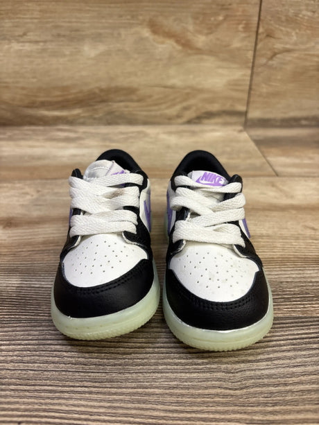 Front view of Air Jordan 1 Retro Low OG TD Black Raspberry sneakers showing black and white uppers, purple accents on wood flooring