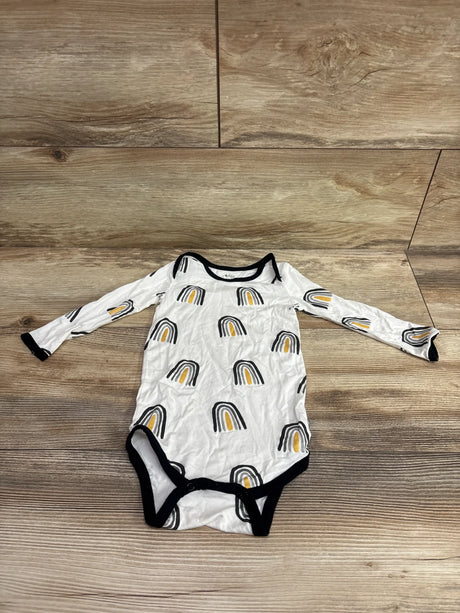 Top view of white Kyte Baby Bamboo Long Sleeve Bodysuit showcasing rainbow print and black trim on wood flooring