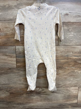 Front view of beige cotton footed baby sleeper with small blue sprig print and ruffle collar on wooden floor
