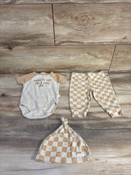 Flat lay of beige ribbed 3-piece set: bodysuit, checkered pants, and knotted hat with ribbed texture and snaps on wood floor