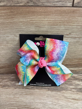 Front view of large rainbow grosgrain hair bow showcasing pink tied center and white layered backing on a black display card over a wood surface