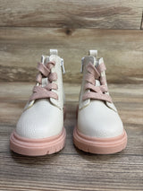 Pair of toddler white leather boots with pink soles and matching pink laces on wooden floor