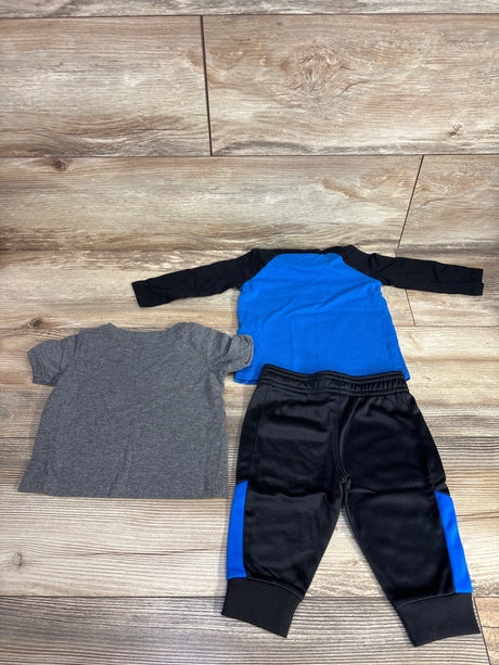 Toddler boys' clothes set with black jogger pants, blue shirt, and gray t-shirt on wood background