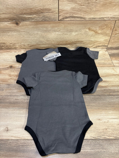 Top view of NHL Golden Knights three-piece bodysuit set, two gray and one black, on a wood floor