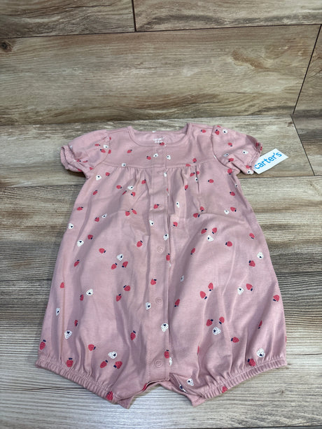 Front view of Carter’s pink 24m strawberry print shortie romper with button front and elastic leg openings on wood