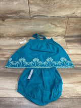 Flat lay of teal smocked top and bloomers with white palm tree embroidery, tie straps, elastic waist on wood background