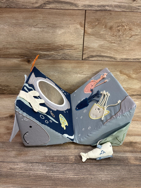 Open view of KiwiCo Ocean Explorer Baby Activity Wedge showcasing ocean-themed sensory toys and mirror on a wood floor