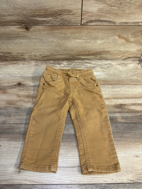 Flat lay of Cat and Jack tan drawstring joggers showing elastic waistband and front pockets on wood background