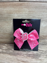 Front view of Barbie pink hair bow showcasing glittered B center and patterned grosgrain ribbon on black Me n Mommy To Be display card