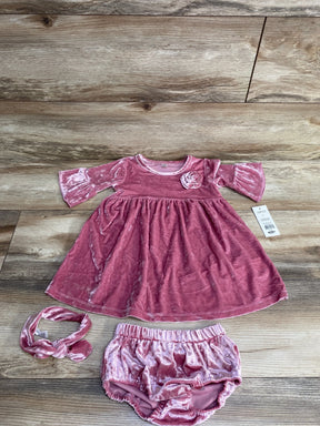 Pink velvet baby dress set with matching bloomers and headband on wooden background