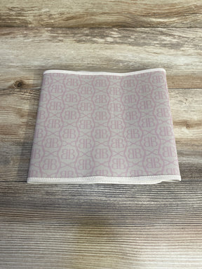 Top-down of Belly Bandit postpartum belly wrap, beige with pink BB monogram, folded to show elastic trim on light wood background
