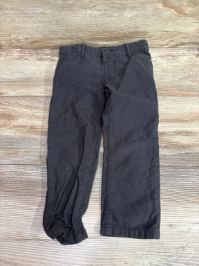 Grey Oshkosh pants for toddlers size 3T laid flat on a light wood background.