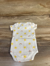Flat lay of white sun-print baby bodysuit (3-6 months) showing yellow sun and rainbow prints on cotton wood background
