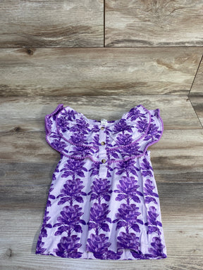 Flat lay of purple ruffle henley top (4T) showing ruffled yoke and front buttons on wood background
