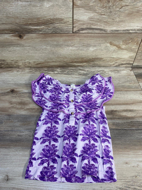Flat lay of purple ruffle henley top (4T) showing ruffled yoke and front buttons on wood background