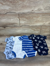 Flat lay of four Member's Mark baby bodysuits (6M) showing solid and striped blue and two dog-print designs on wood background