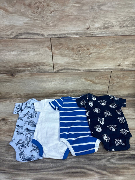 Flat lay of four Member's Mark baby bodysuits (6M) showing solid and striped blue and two dog-print designs on wood background
