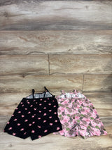 Flat lay of two 4T tank rompers: black with pink flowers and pink with tropical leaf and leopard print on light wood
