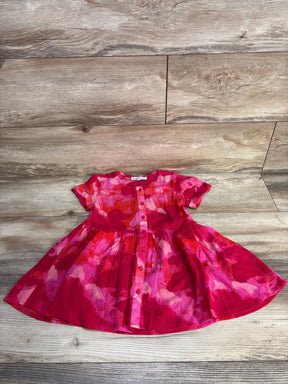 Pink and red short sleeve baby dress with abstract floral pattern on wooden floor