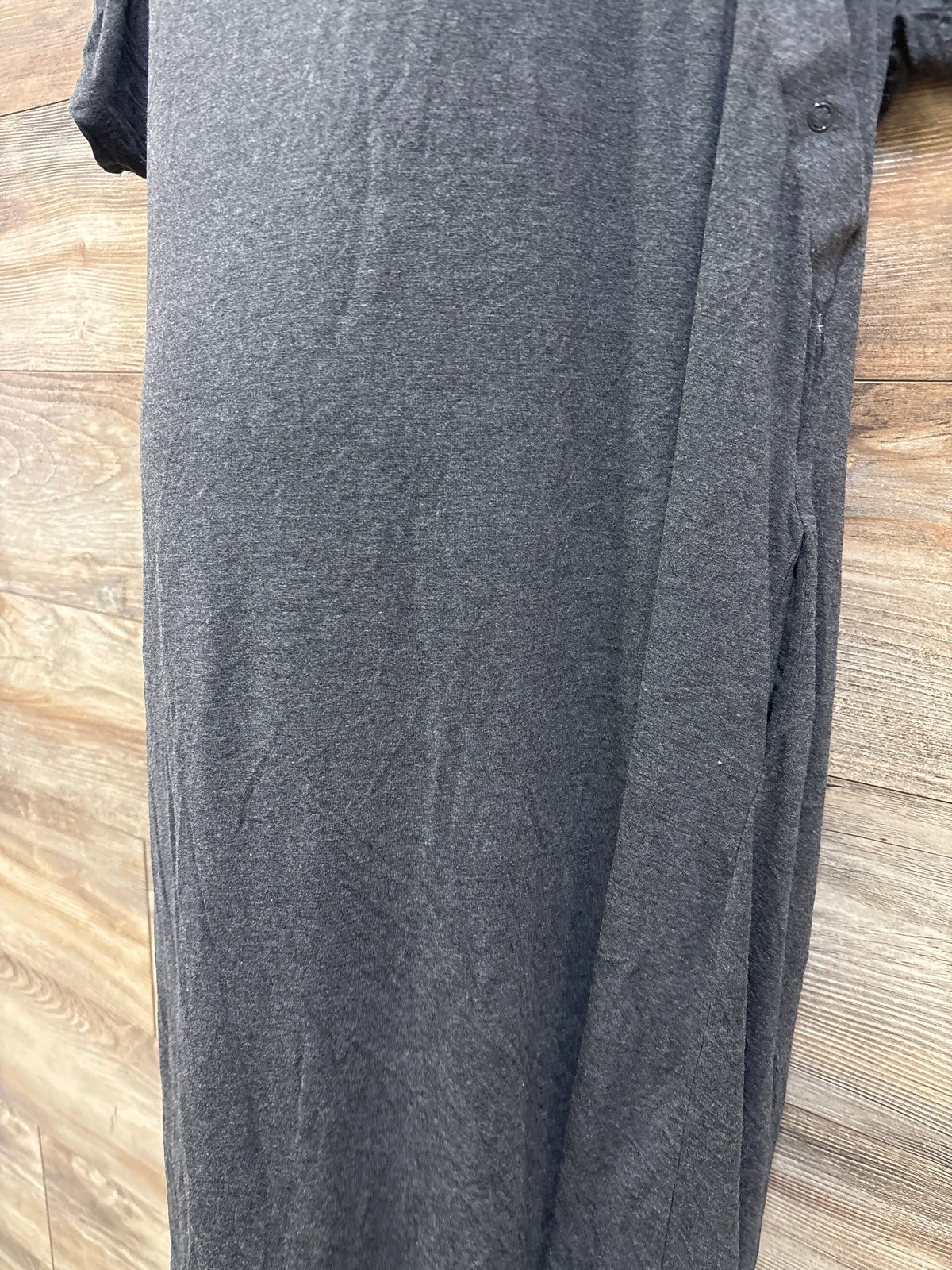 Front view of gray Frida delivery and nursing gown showcasing snap closures on a wood floor