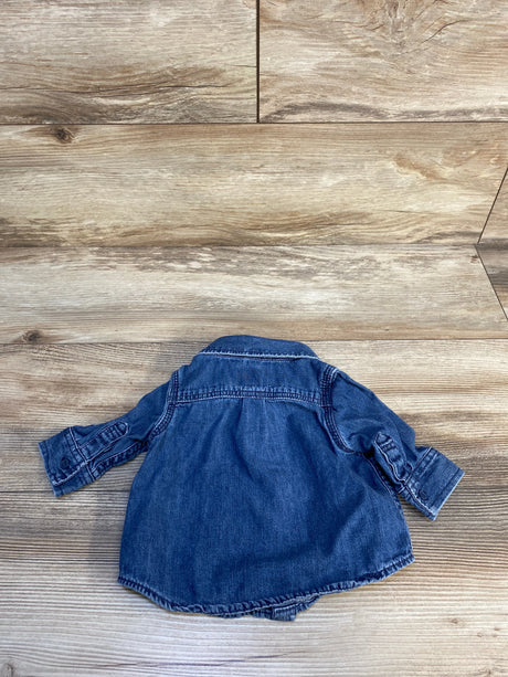 Blue denim long sleeve baby shirt displayed on wooden floor