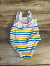 Colorful striped baby swimsuit with rainbow lines and playful pattern on wooden background