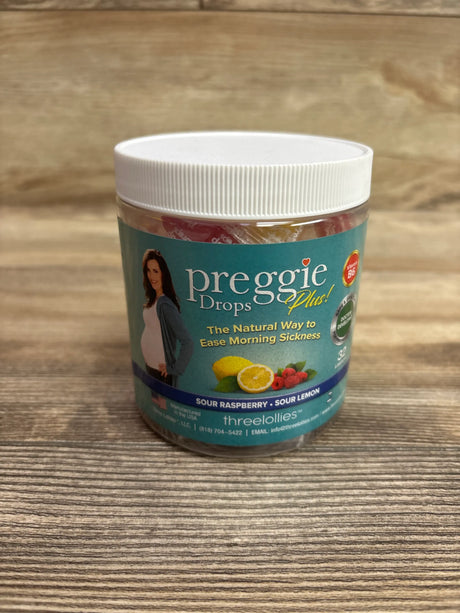 Front view of ThreeLollies Preggie Pop Plus Drops container showcasing sour raspberry and sour lemon flavors on a wood-grain surface