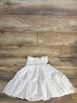 White tiered girls dress with ruffle sleeves displayed on wood floor