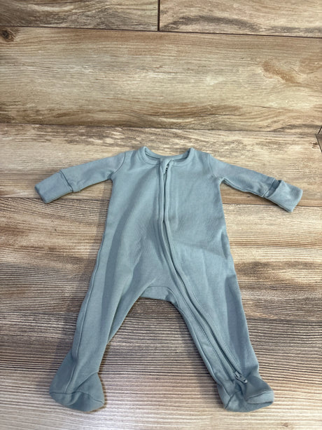 Flat lay of sage Colored Organics footed zipper sleeper showing front zipper and fold-over sleeve cuffs on wood background