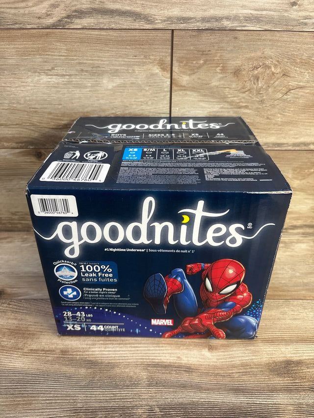 Angled front view of Goodnites Marvel underwear box showing Spider-Man art, XS (28–43 lb) size and 44-count on wood background