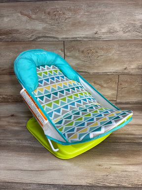 Colorful baby bather with geometric mesh pattern and turquoise trim on wooden background