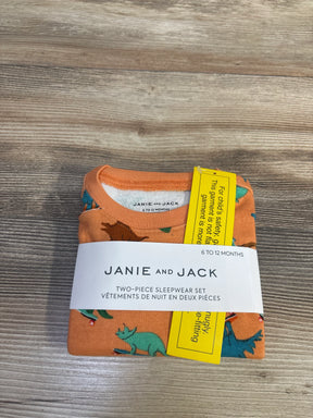 Top view of NEW Janie & Jack Dino Skate 2pc Pajama Set Orange sz 6-12m folded in original Janie and Jack sleepwear band on wood plank background