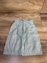 Flat lay of blue and white vertically striped toddler pants with elastic ruffled waist and drawstring on wood floor