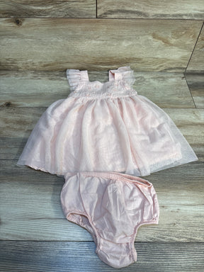 Light pink baby dress with ruffle sleeves and matching bloomers on wooden background