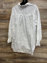 White long sleeve blouse with high collar and pleat detail, displayed on wooden background