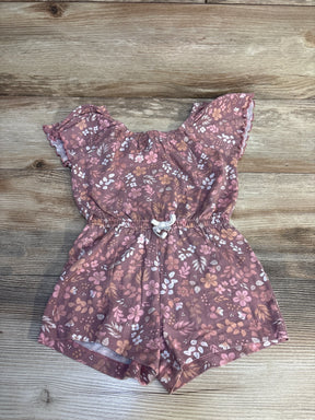 Floral baby romper with ruffled sleeves and drawstring waist, laid on wood floor