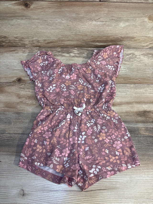 Floral baby romper with ruffled sleeves and drawstring waist, laid on wood floor