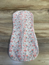 Top-down view of SwaddleMe newborn pod swaddle showing pink coral floral print on white fabric on wood background