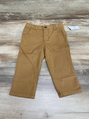 Front flat lay of Old Navy 360-degree stretch skinny pants, bandolier brown, button waist and pockets on wood background