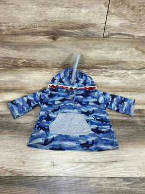 Top-down view of blue Mudpie toddler shark-print hoodie with hood fin, red-lined hood edge and front pocket on wood floor