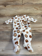 Flat lay of white plush footed baby sleeper with brown lion faces and embroidered ROAR patch zip front on light wood